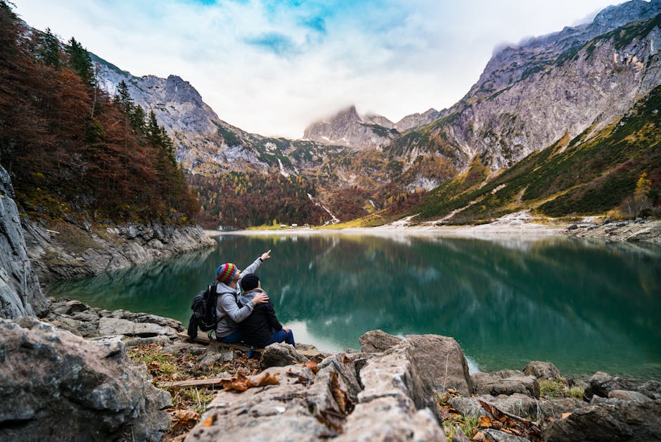 A couple enjoys a scenic view of Hallstatt Lake surrounded by mountains and forest.